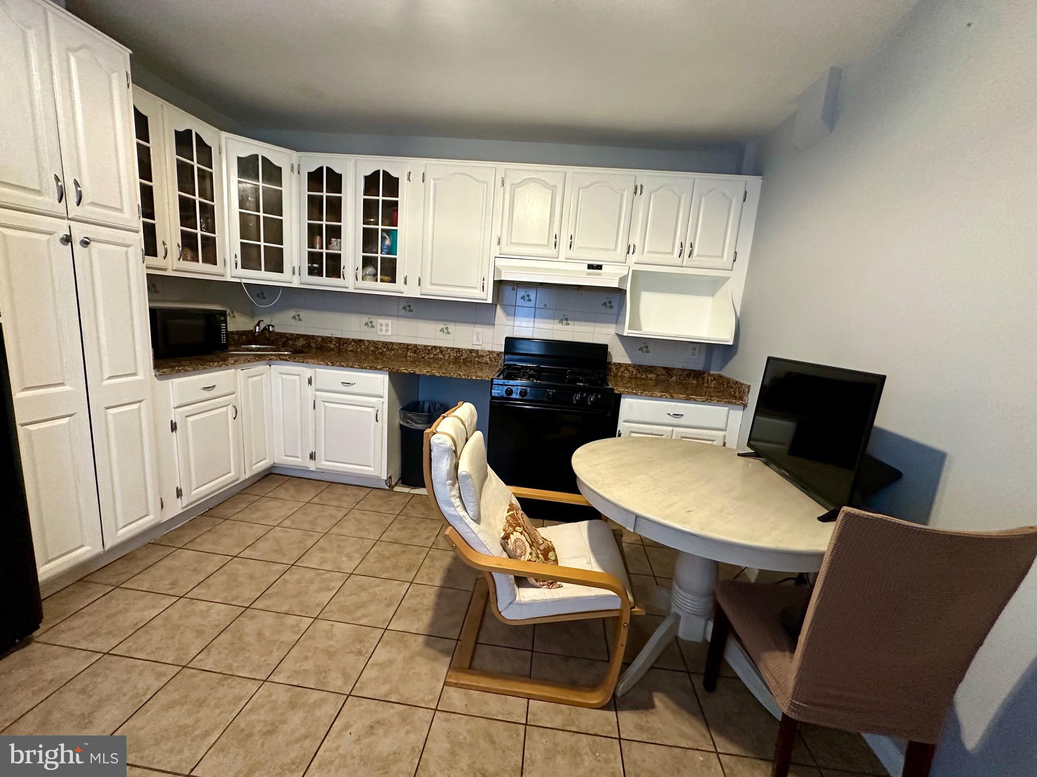 1707 Harman Avenue Baltimore, MD 21230 - Photo 15 of 18 a kitchen with stainless steel appliances a dining table chairs and granite countertops