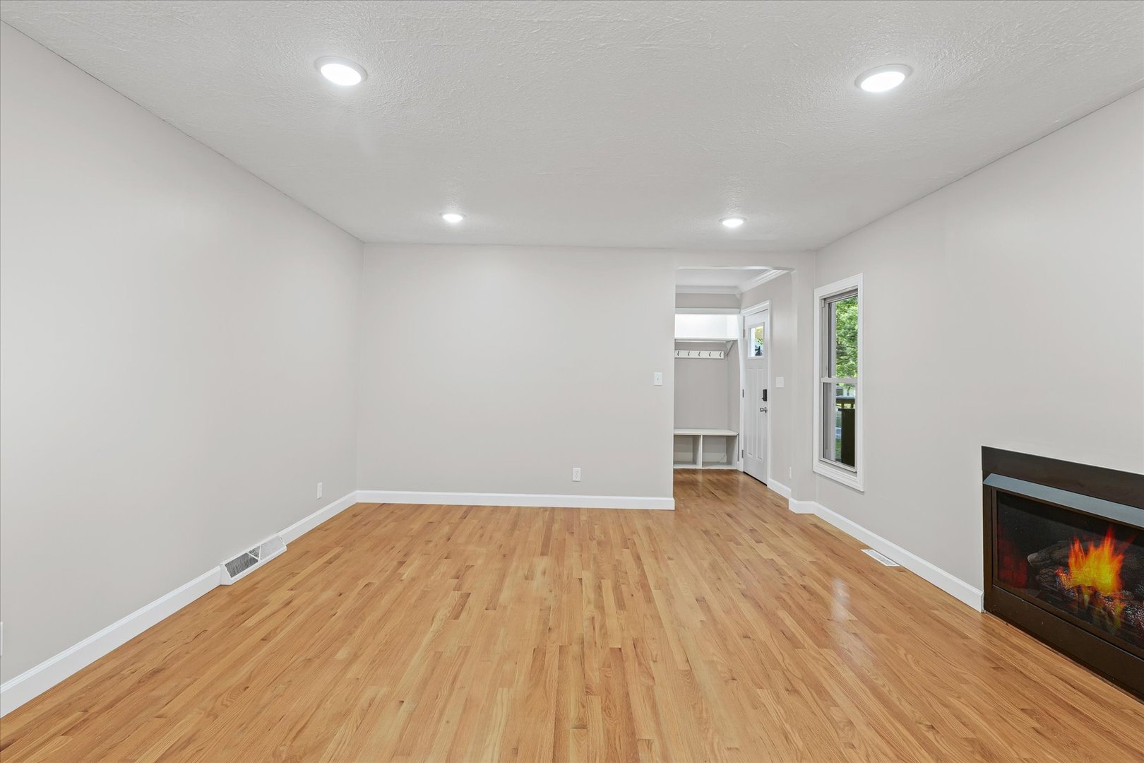 1101 East Pin Oak Drive Mahomet, IL 61853 - Photo 13 of 57 a view of an empty room with wooden floor and a fireplace