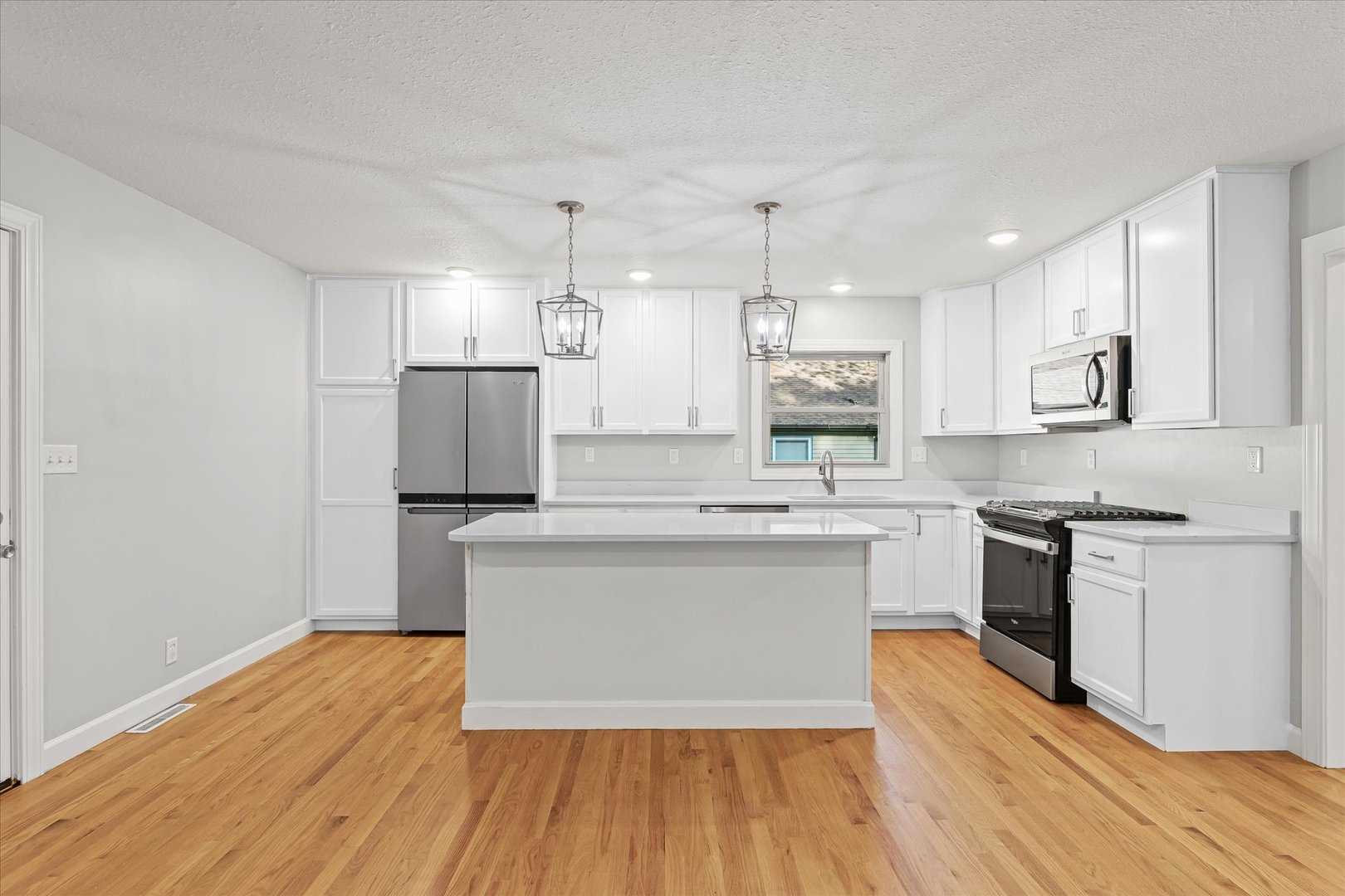 1101 East Pin Oak Drive Mahomet, IL 61853 - Photo 14 of 57 a large kitchen with cabinets wooden floor and stainless steel appliances