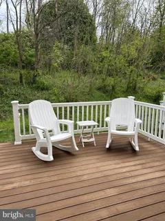 a view of a patio with couches chairs and wooden floor