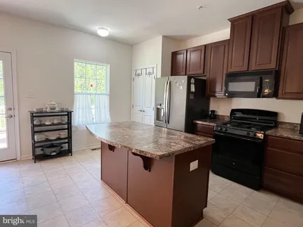 a kitchen with granite countertop a stove cabinets and refrigerator