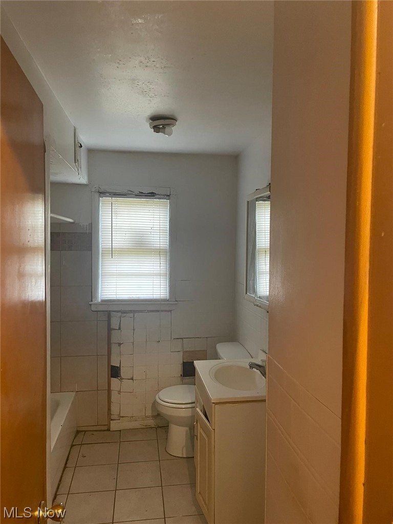11153 Prospect Road Strongsville, OH 44149 - Photo 3 of 25 Full bathroom featuring vanity, toilet, tile walls, tile flooring, and shower / washtub combination