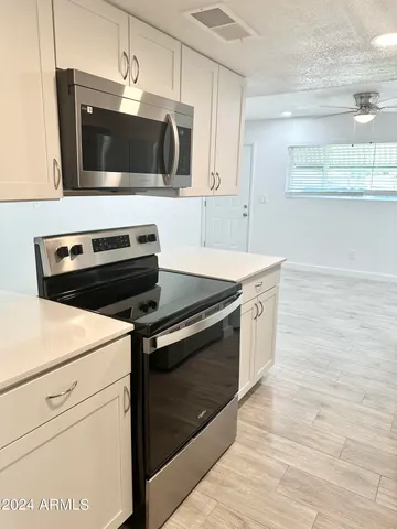 a kitchen with stainless steel appliances a stove microwave and cabinets