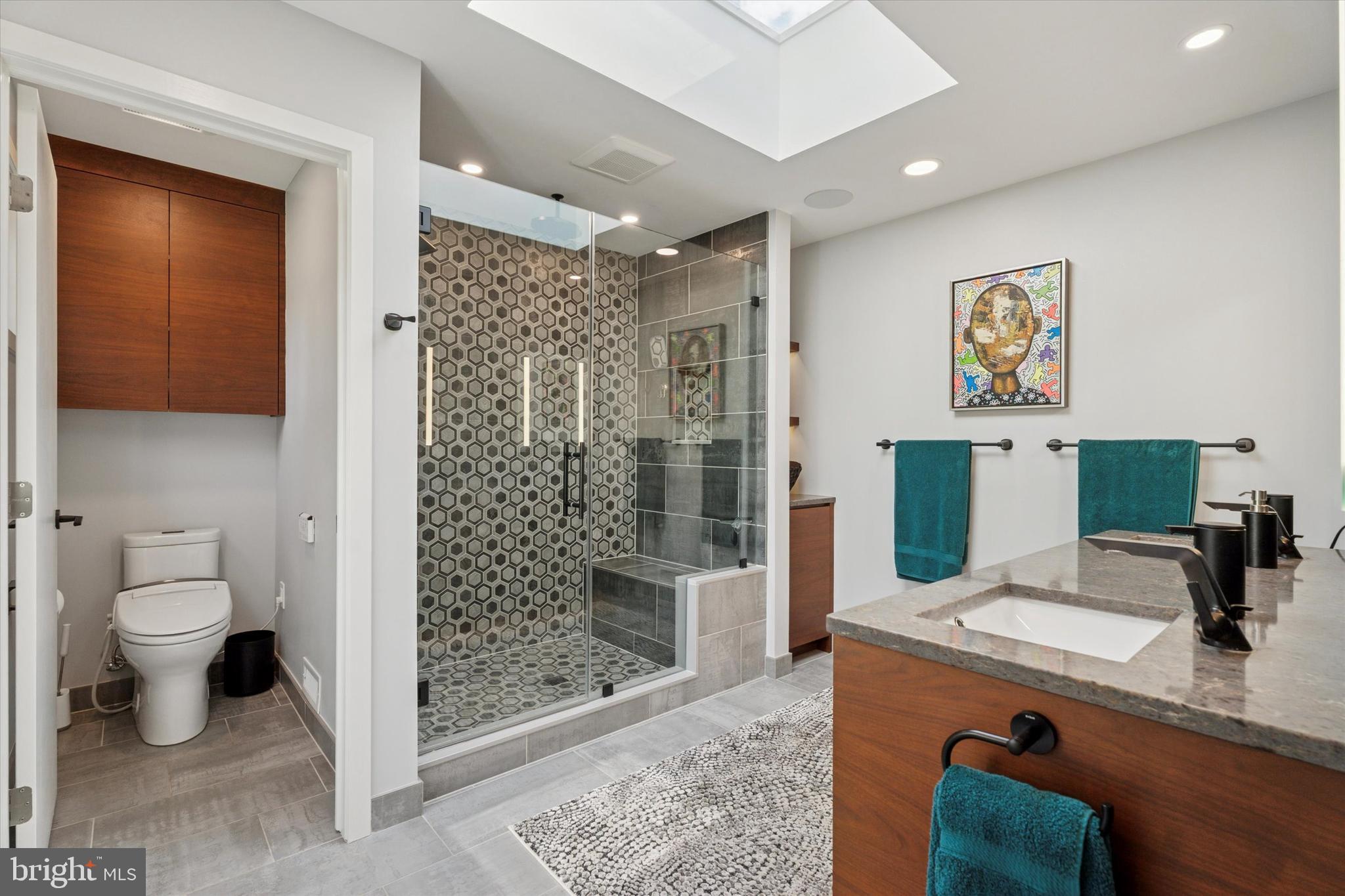 1641 Chattin Road Glenside, PA 19038 - Photo 30 of 48 a bathroom with a granite countertop sink a toilet a mirror and shower