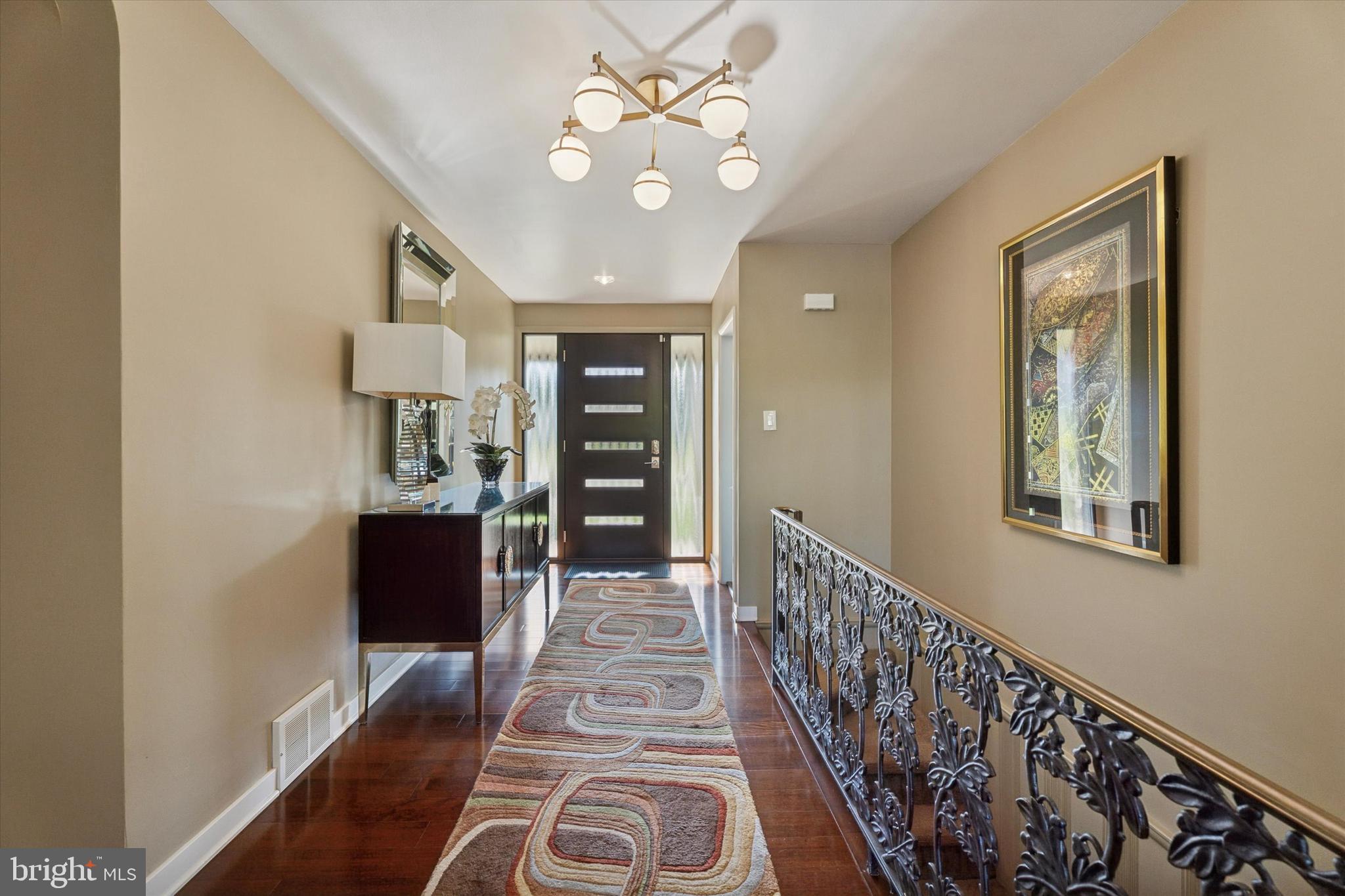 1641 Chattin Road Glenside, PA 19038 - Photo 6 of 48 a view of a hallway with wooden floor and a chandelier