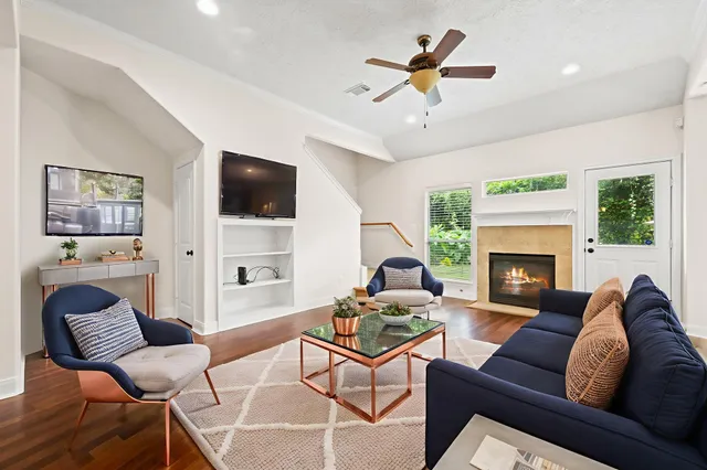 a living room with furniture a flat screen tv and a fireplace
