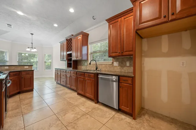 a kitchen with stainless steel appliances granite countertop a stove a sink and a refrigerator
