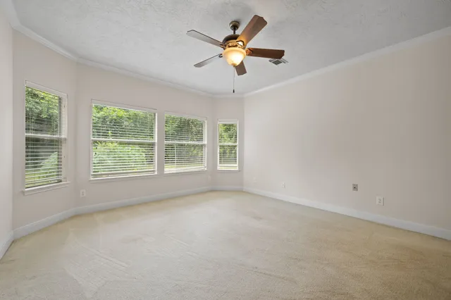 an empty room with a window and a fan