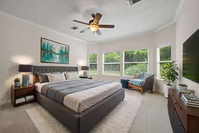 a bedroom with a large bed couch and a window