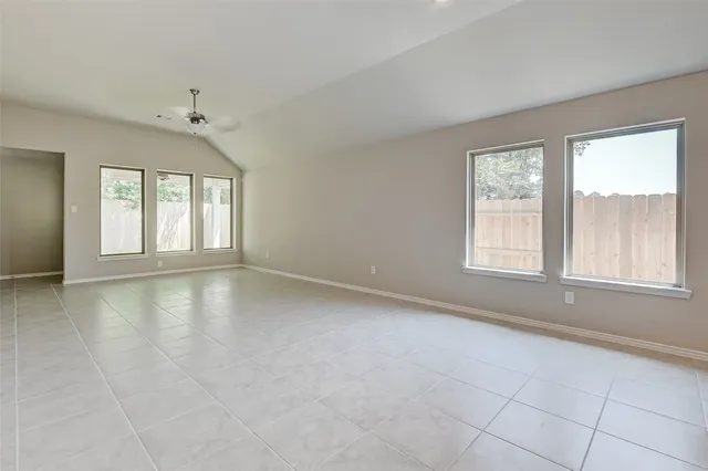 an empty room with furniture and a ceiling fan