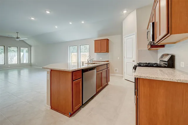 a kitchen with granite countertop cabinets stainless steel appliances and a sink