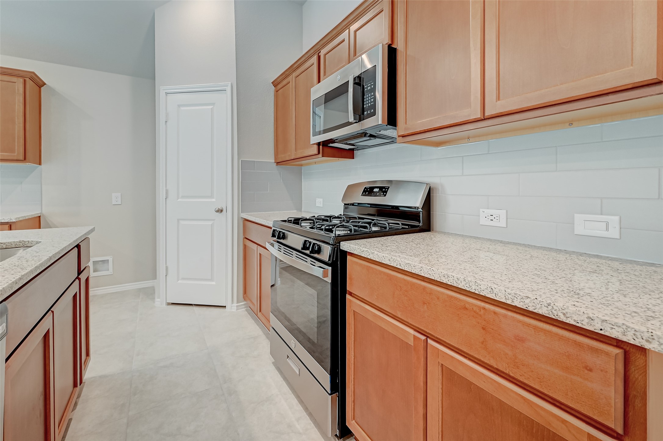32037 Towering Birch Trail Conroe, TX 77385 - Photo 10 of 38 a kitchen with granite countertop cabinets stainless steel appliances and a sink