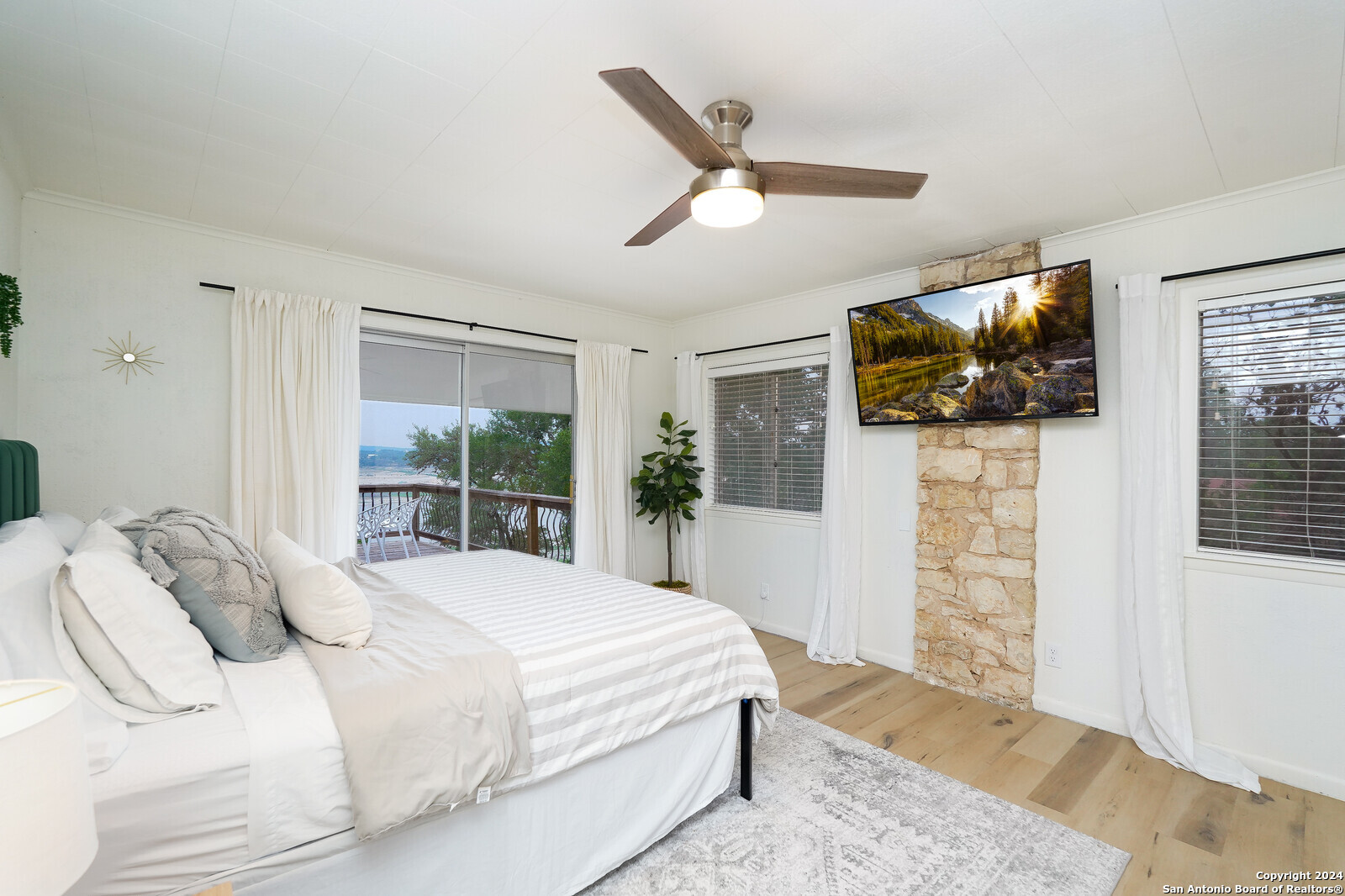 550 County Road 262 Mico, TX 78056 - Photo 25 of 58 a bedroom with a bed a flat screen tv and a window