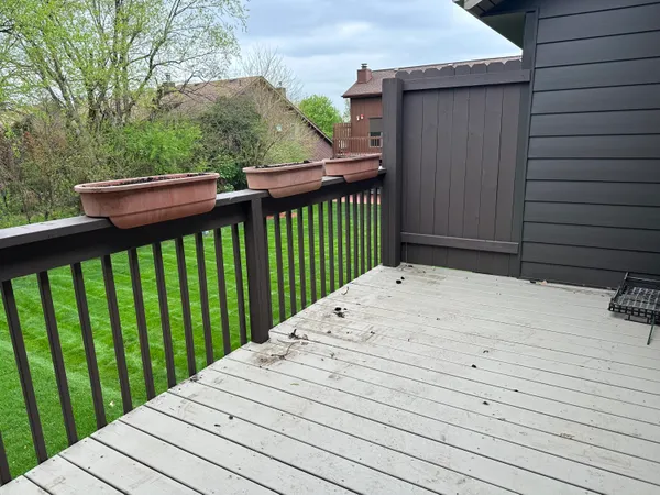 a view of balcony with wooden floor and fence
