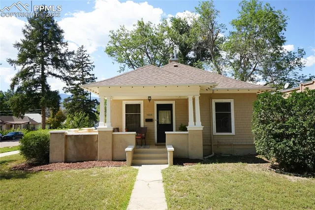 a view of a house with a backyard and sitting area