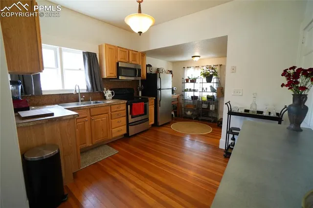 a kitchen with stainless steel appliances a stove sink and wooden floor
