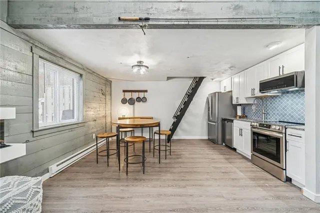 a dining room with wooden floor a chandelier a wooden table and chairs
