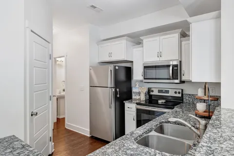 a kitchen with stainless steel appliances granite countertop a refrigerator a stove top oven a sink and dishwasher