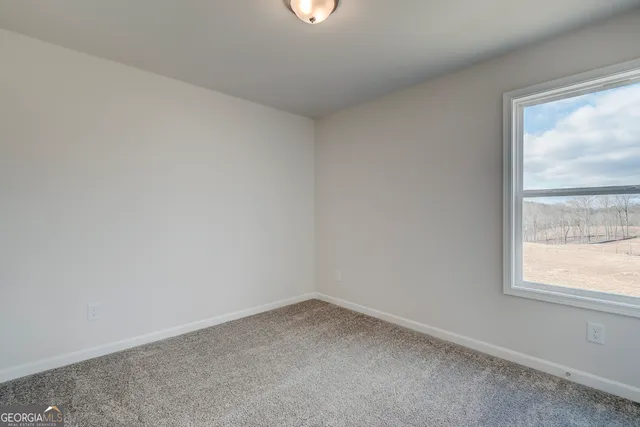 a view of a hallway with wooden floor and closet area