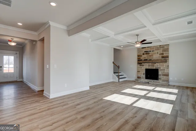 a large kitchen with stainless steel appliances a large counter top a stove a sink dishwasher and a refrigerator with wooden floor