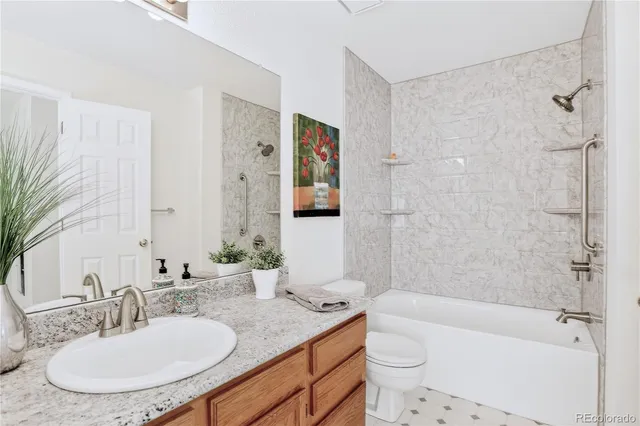 a bathroom with a granite countertop sink toilet and shower