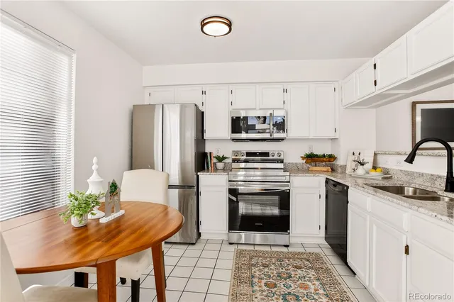 a kitchen with stainless steel appliances a stove a sink a microwave a refrigerator and cabinets
