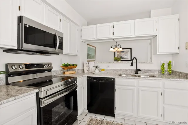 a kitchen with white cabinets and appliances