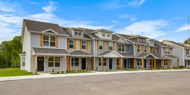 front view of a brick house with a yard