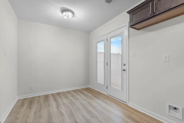 a view of an empty room with wooden floor and closet