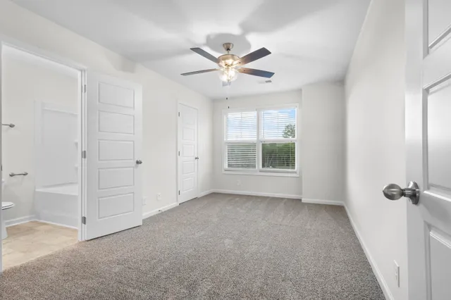 a view of a livingroom with a ceiling fan and window