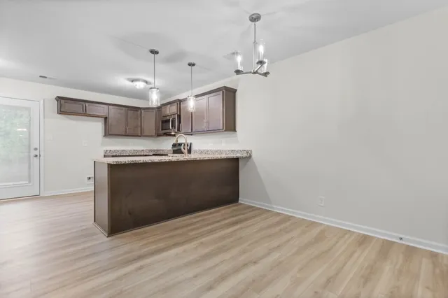 a kitchen with kitchen island a sink and a stove with wooden floor
