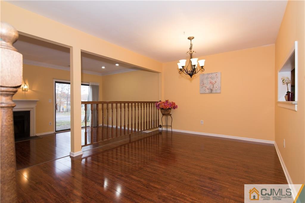 1106 Timber Oaks Road, Unit 1106 Edison, NJ 08820 - Photo 5 of 20 a view of a room with wooden floor a fireplace and windows