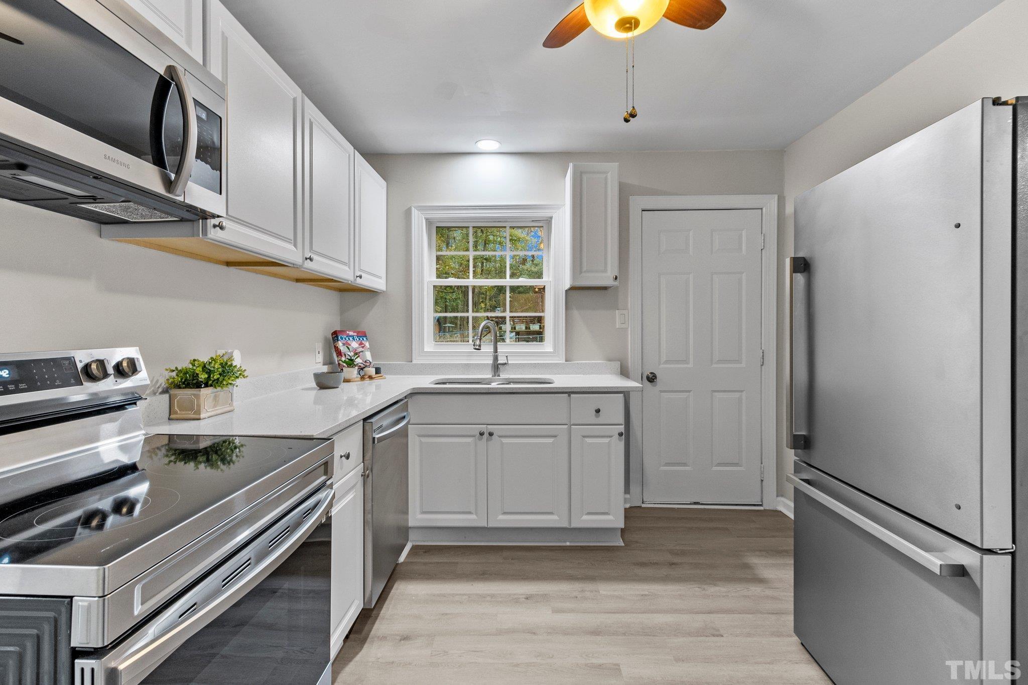 1124 Harper Road Raleigh, NC 27603 - Photo 29 of 59 a kitchen with a sink stove and cabinets