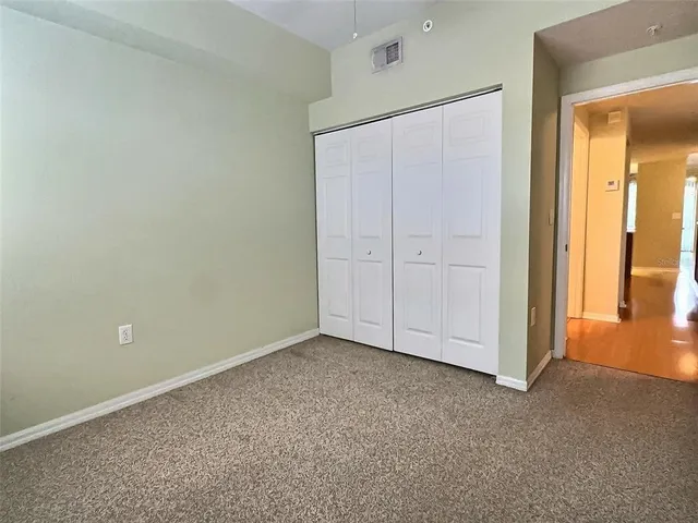 an empty room with closet and mirror