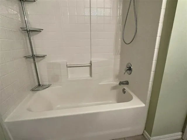 a white bath tub sitting next to a white sink and a shower