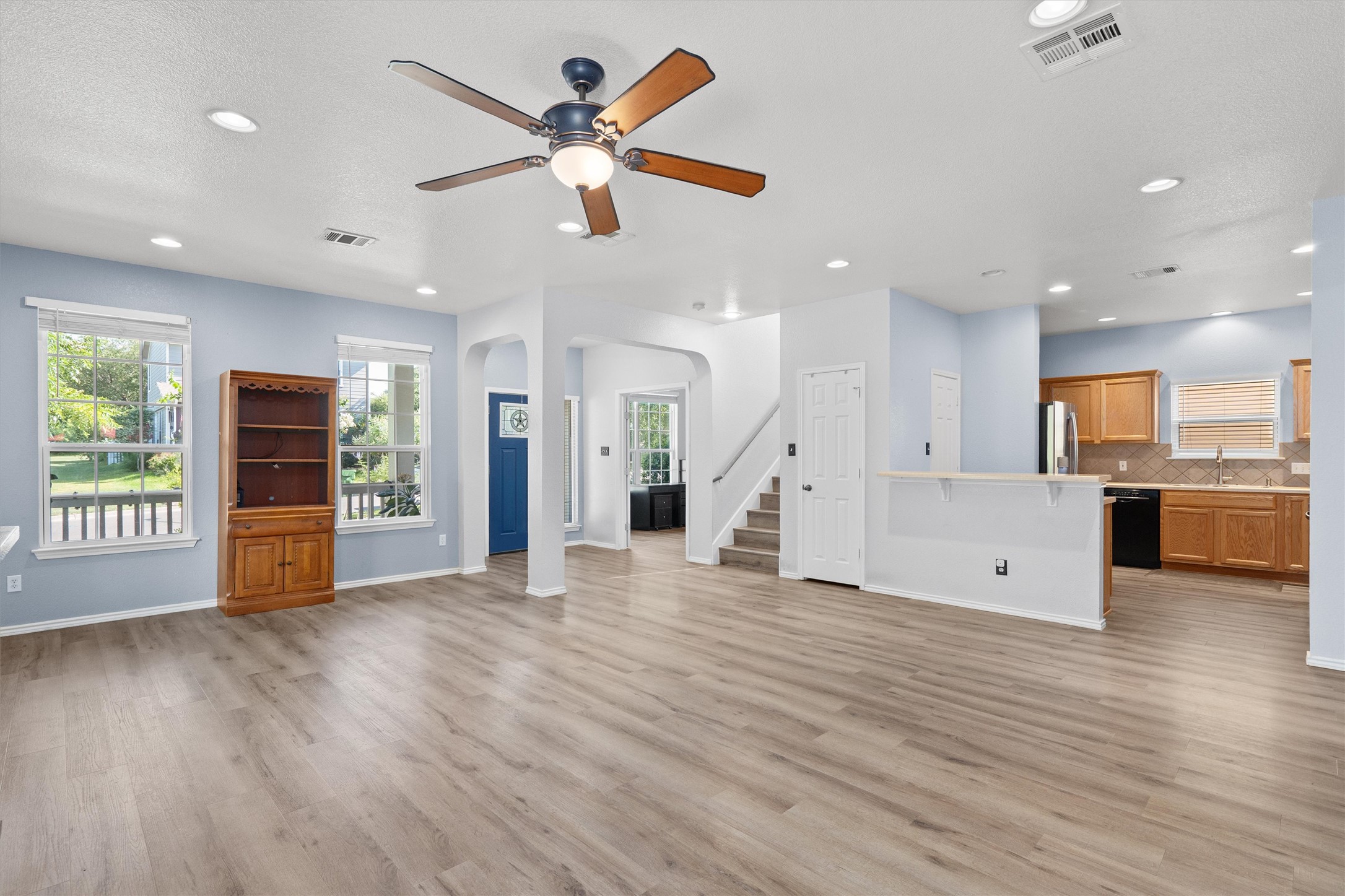 1833 Thompson Trail Round Rock, TX 78664 - Photo 5 of 40 An open-concept living area flows seamlessly into the kitchen, featuring modern wood-look flooring and generous natural illumination.