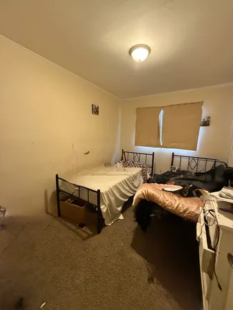 a bedroom with a bed and a lamp with the wall