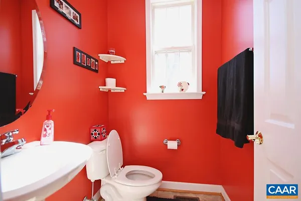 a bathroom with a toilet a sink and mirror