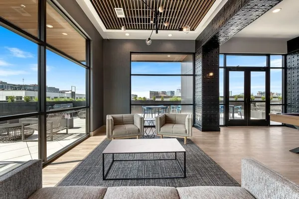 a living room with furniture and a floor to ceiling window