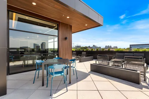 a outdoor kitchen with a sink dining table and chairs