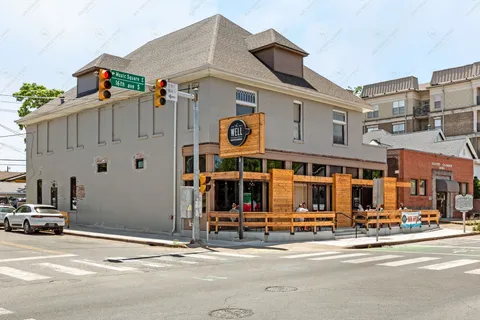 a view of a building with car parked on the road
