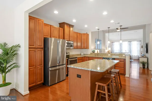 a kitchen with stainless steel appliances granite countertop a refrigerator a sink and a stove