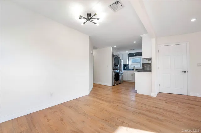 an empty room with wooden floor and window