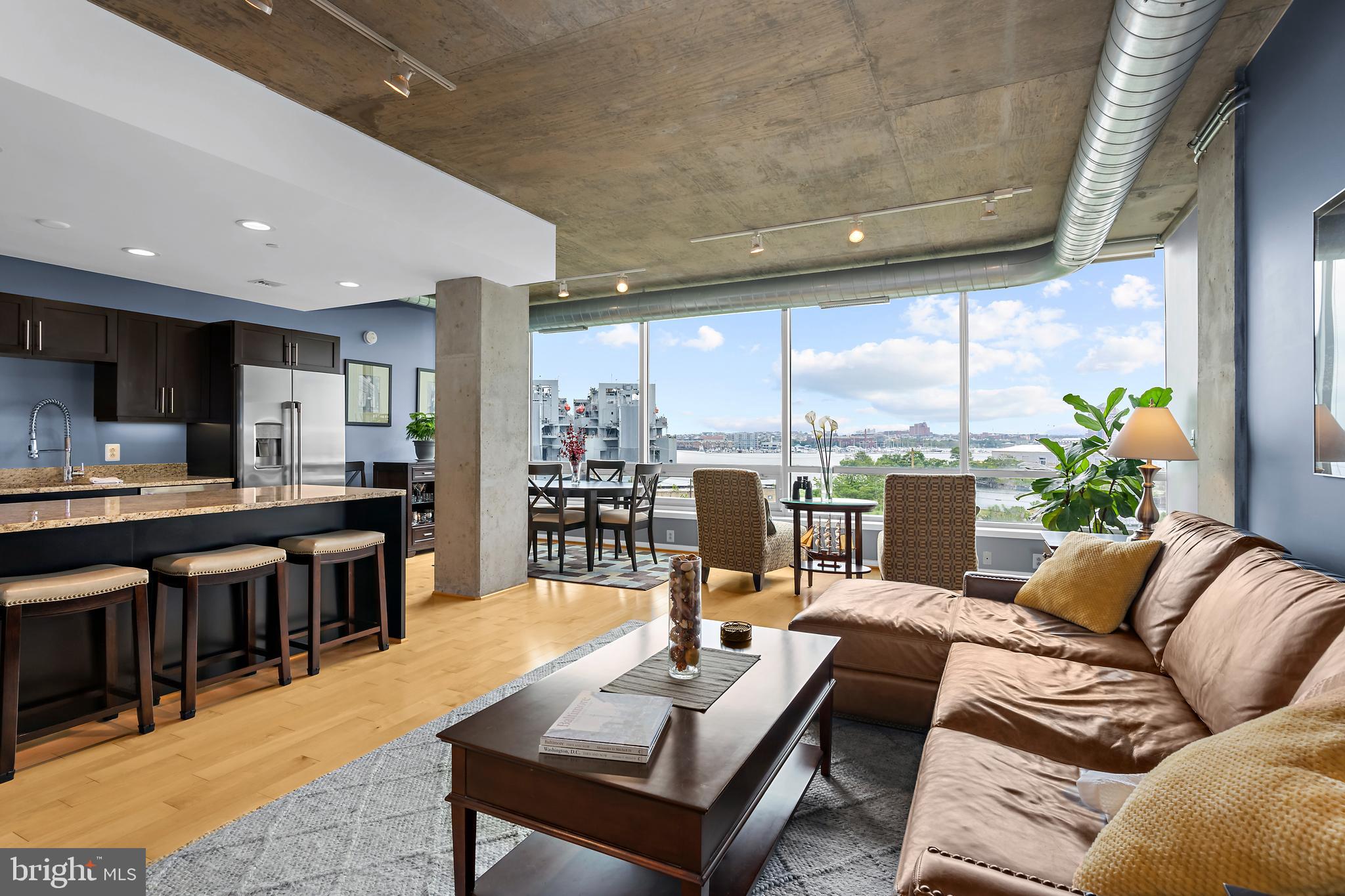 a living room with furniture kitchen view and large windows
