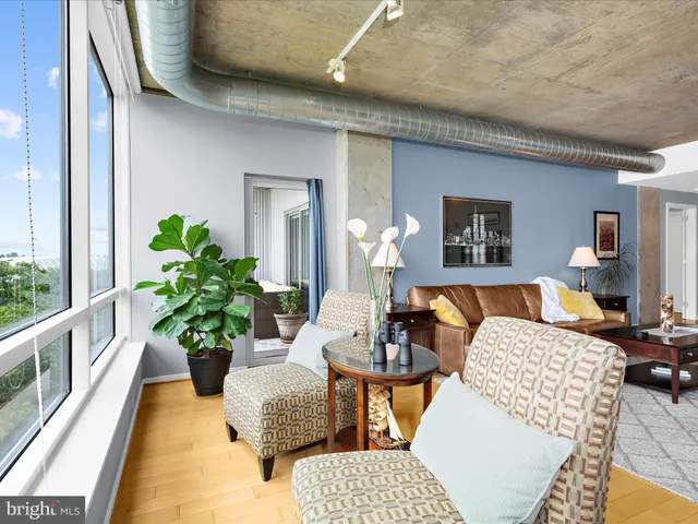 a living room with furniture kitchen view and a large window