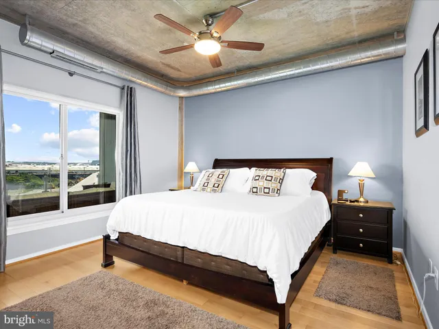 a bedroom with a bed and a large window