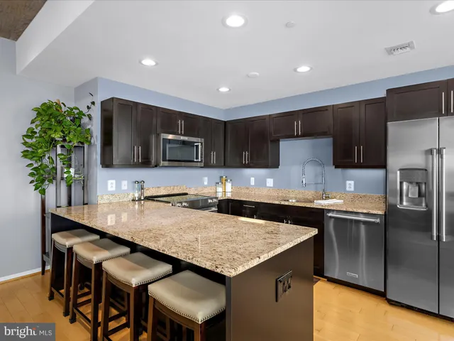 a kitchen with stainless steel appliances granite countertop a sink stove and microwave