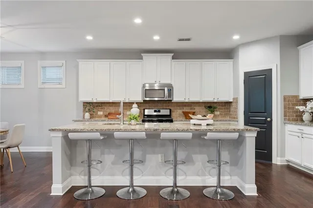 a view of a dining room with furniture a kitchen and chandelier
