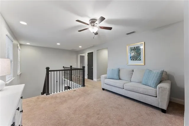 an empty room with a chandelier fan and windows