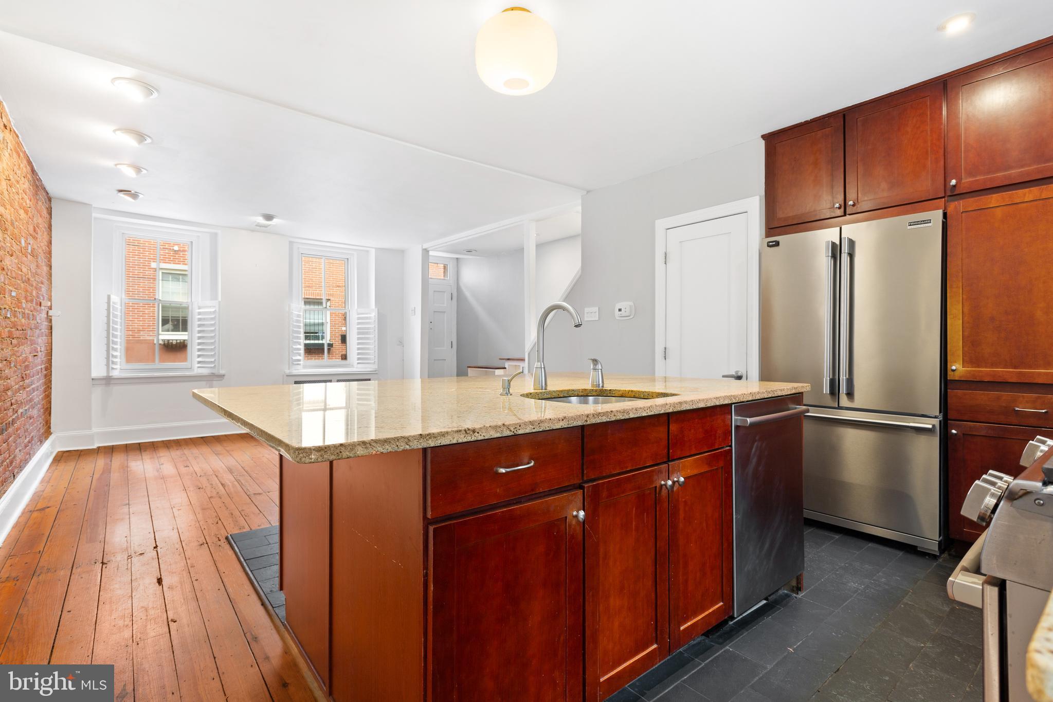 504 Kauffman Street Philadelphia, PA 19147 - Photo 12 of 34 a kitchen with stainless steel appliances granite countertop a refrigerator a sink dishwasher and wooden cabinets with wooden floor